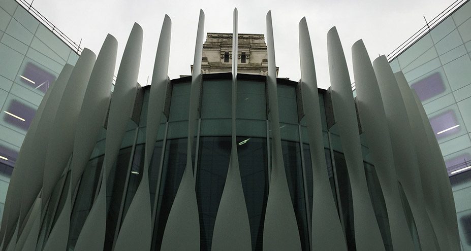 Trinity Square Blades: tall curved fibreglass blades forming a screen around a glass building